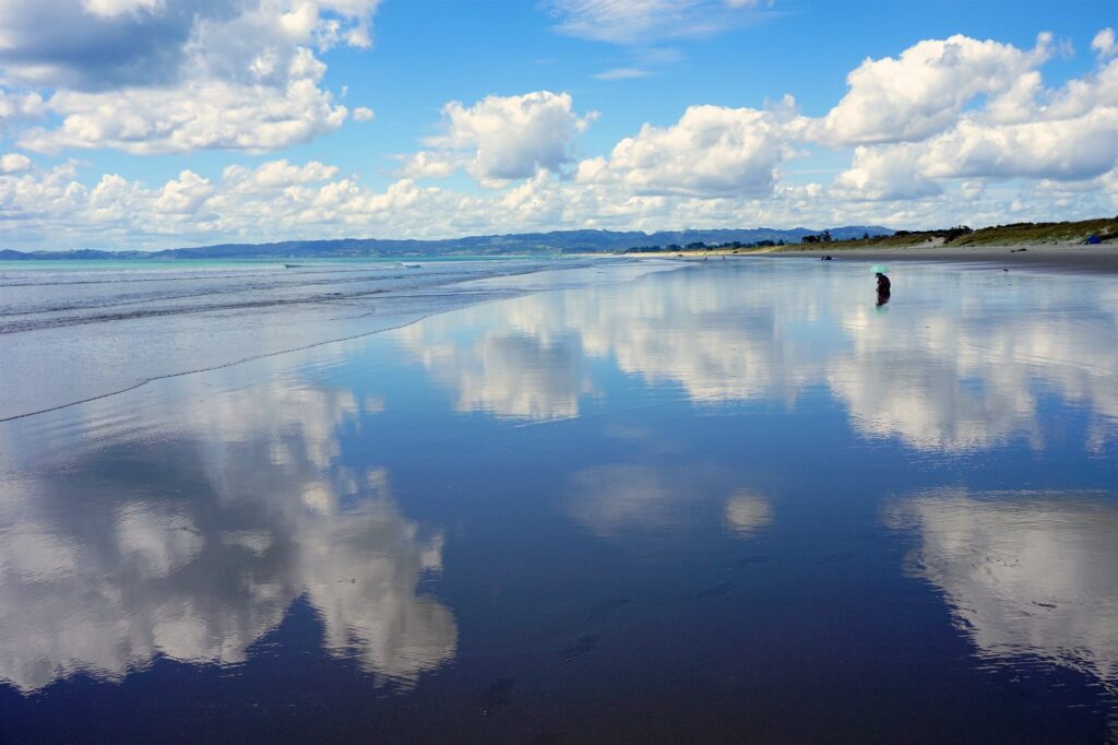 Uretiti Beach with reflecting sky and clouds